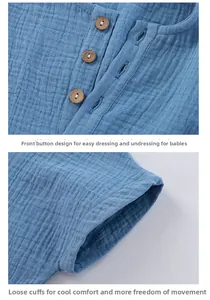 Detail showing natural wood buttons and sleeve stitching on light blue cotton baby top