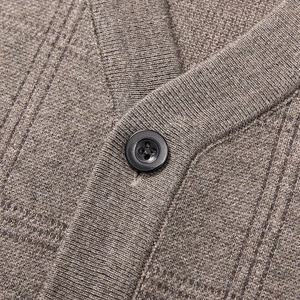 Detail of V-neck knit cardigan showing a resin button and premium fabric texture
