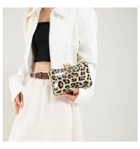 Close-up of leopard print evening bag with golden metal clasp held by a model