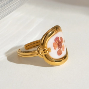 Detailed macro view of an adjustable gold ring featuring real orange dried flower inlay