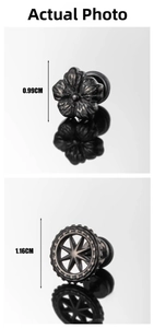 Detailed macro view of vintage gear and flower shaped stainless steel ear studs