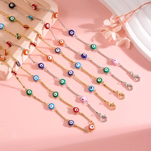 Colorful evil eye chain bracelets in gold and silver finish on elegant pink background