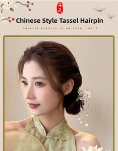 Close-up of a silver Chinese tassel hair pin with pearls and floral details on a model