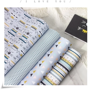 Détail macro de motifs géométriques sur rouleaux de papier cadeau kraft blanc 80g