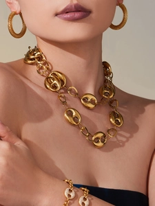 Gros plan d'un collier à maillons en or 18 carats et d'un ensemble de bijoux sur modèle