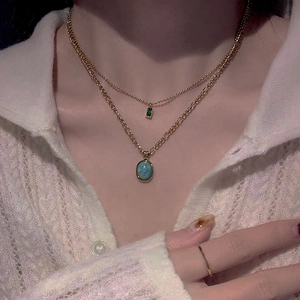 Double-layered gold necklace with oval amazonite stone and green gem for beach vacations