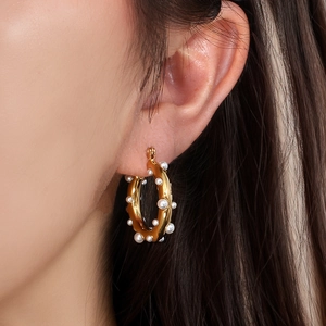 Polished 18K gold hoop earrings with inlaid white pearls for a minimalist luxury look