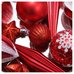 Macro shot of red Christmas ornaments with glitter, snowflakes, and matte star textures