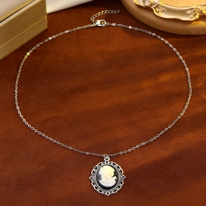 Vintage silver cameo necklace with black lady portrait pendant on brown velvet background
