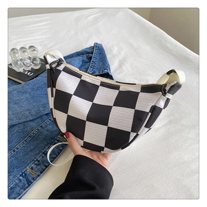 Detail of checkered crescent bag with textured patterns and high-quality zipper closure