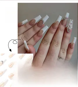 Detailed view of long French nails with white embossed flowers and rhinestone accents