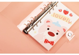 Detail of A6 PVC binder showing pink inner pages with metal rings and lovely bear graphics