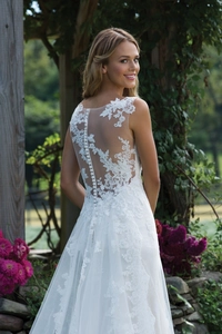 Détails exquis du dos d'une robe de mariée en dentelle blanche avec mesh et boutons