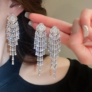 Close-up of dangling silver tassels and sparkling cubic zirconia on long drop earrings