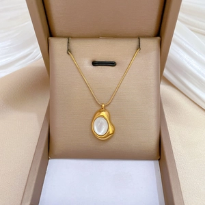 Macro detail of a gold titanium necklace with a cat-eye stone pendant in a gift box
