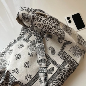 Macro view of patterned canvas tote lining with woven brand label and ethnic print detail