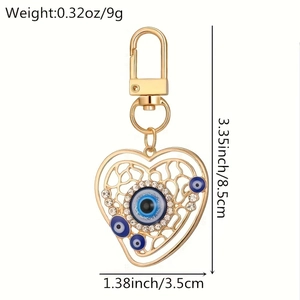 Macro shot of heart-shaped evil eye keychain with gold plating and blue rhinestones