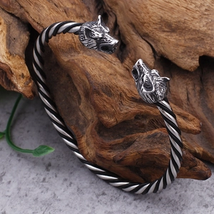 Detail of Nordic wolf head open bangle with black and silver twisted rope pattern texture