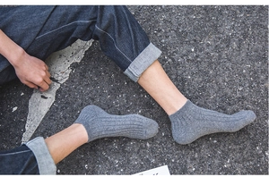 Detailed view of grey heathered ribbed cotton crew socks for men in a casual street setting