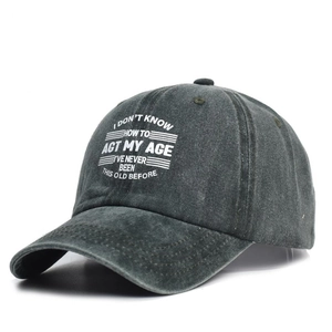 Dettaglio del berretto da baseball in cotone grigio lavato con slogan bianco su sfondo bianco