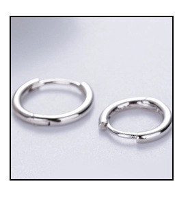 Macro shot of minimalist S925 sterling silver hoop earrings with polished metal finish