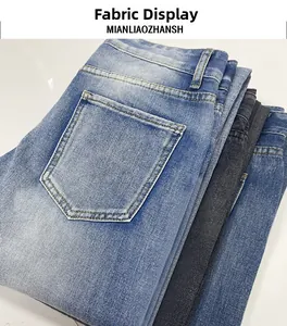 Close-up of stacked washed denim jeans in blue and black colors showing fabric detail