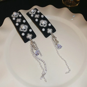 Detail of luxury hair clip with pearl clover and purple crystal tassel on porcelain