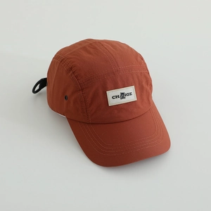 Rust red water-resistant 5-panel camper cap with CHANGE logo and bear patch detail