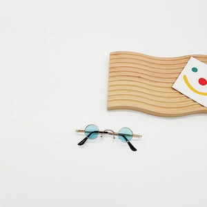 Close-up of small round retro sunglasses with blue lenses and golden metal frame