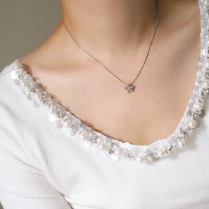 Elegant daisy flower necklace in silver stainless steel worn by a model in white