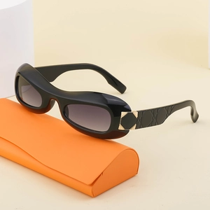 Fashionable black oval Y2K sunglasses with gradient grey lenses and orange leather case
