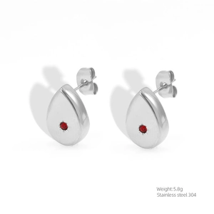 Macro shot of silver stainless steel teardrop earrings with central red zircon stones
