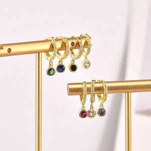 Close-up of gold huggie earrings with multi-color round zircon drops on T-stands