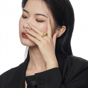 Golden spiral textured S925 sterling silver ring worn on a model's index finger