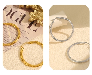 Detail view of large twisted rope hoop earrings in gold and silver metallic finishes