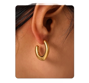 Close-up of a minimalist 18k gold plated stainless steel C-shaped earring on a model