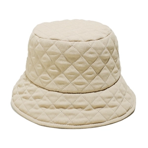 Detail of beige quilted bucket hat showing diamond stitching and soft fabric texture