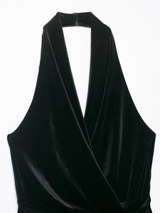 Detailansicht eines schwarzen Samtkleides mit tiefem V-Ausschnitt und Neckholder-Knopf