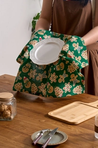 Detail of Christmas napkin with holiday prints being held over a wooden table
