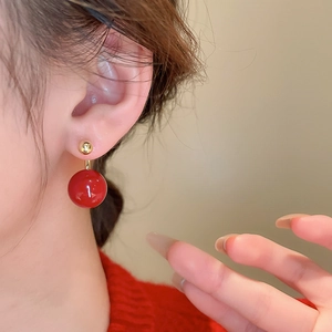 Vintage red pearl drop earrings with gold plating shown on a model's ear profile