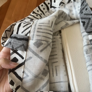 Detail of linen fabric with geometric patterns and neat overlock stitching on a bag