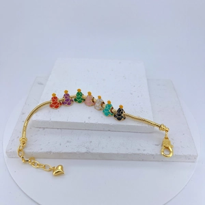 Golden charm bracelet with multi-color beads and heart pendant on stone display