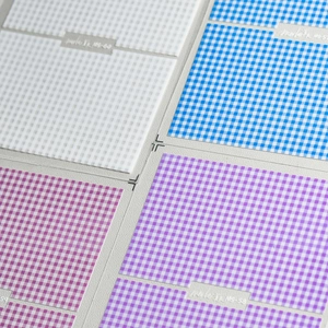 Close-up of 5D embossed gingham nail stickers in sky blue, purple, and rose red colors