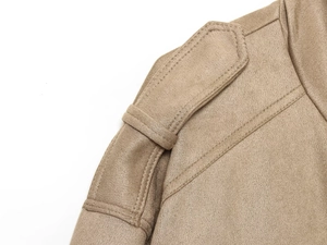 Détail des pattes d'épaule et double couture fine sur veste en daim de couleur camel