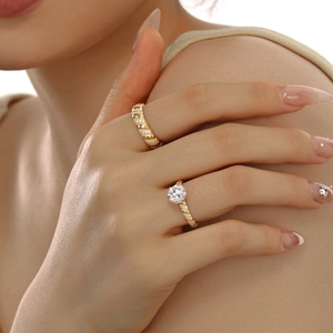 Close-up of dual gold S925 silver rings with twisted bands and pavé diamonds on a model