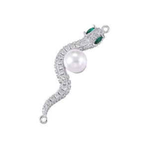 Detail of silver snake pendant with white pearls, zircon stones, and green gemstone eyes