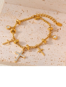 Macro shot of gold-plated box chain bracelet with sparkling cross pendants and crystals