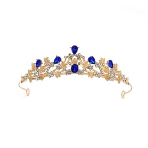 Detail of a vintage golden baroque crown with blue teardrop stones and sparkling crystals