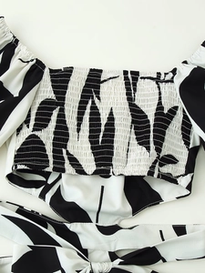 Detailed view of the smocked bodice and leaf print pattern on this summer dress