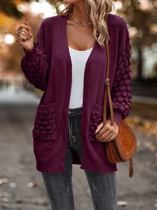 Detail of deep purple long knit cardigan with unique 3D popcorn texture on sleeves and pockets